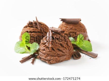 three chocolate ice cream scoops with chocolate flakes and herbs