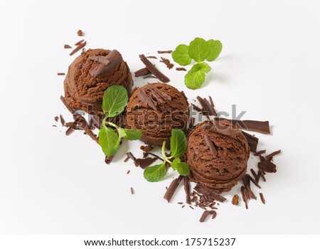 three scoops of chocolate ice cream with chocolate flakes and mint