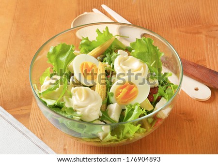bowl of garden salad with boiled eggs and mayonnaise, on the table