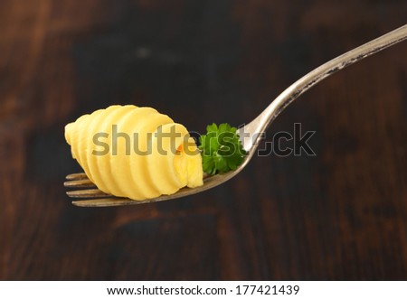 butter curl with piece of parsley on the fork