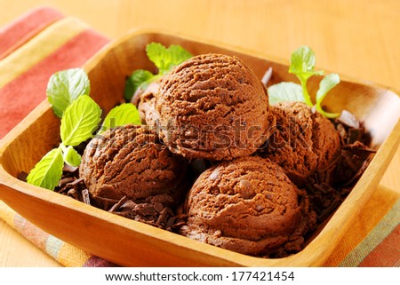 chocolate ice cream scoops with chocolate flakes served in a wooden bowl