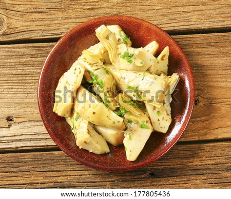 pickled artichoke hearts with herbs, served on a plate