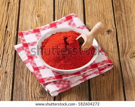 bowl with red ground pepper and immersed measuring spoon