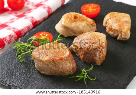 baked pork tenderloin with fresh tomatoes, served on the slate board