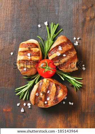 grilled pork tenderloin with fresh tomato, thyme and crystal salt served on the wooden board