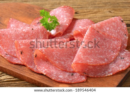 sliced salami with high fat, served on the wooden board