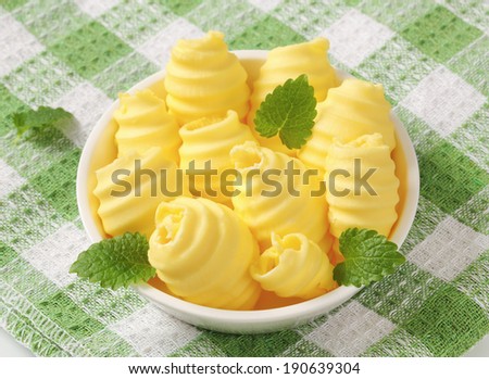 bowl of yellowish butter curls, on the table with green square linen