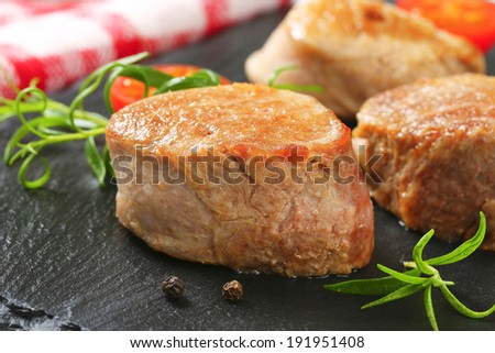 medium rare baked pork tenderloin served on the slate board