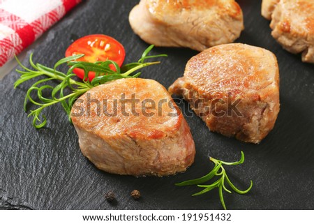 baked pork tenderloin served with tomatoes on the slate board