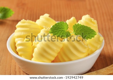 tiny butter curls decorated with herb, in the bowl
