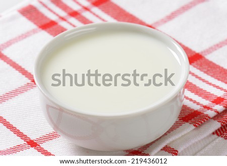 bowl of milk on the fabric linen with red lines