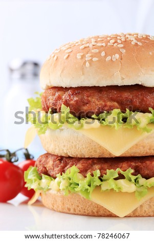 Detail of double cheeseburger, cherry tomatoes on a vine