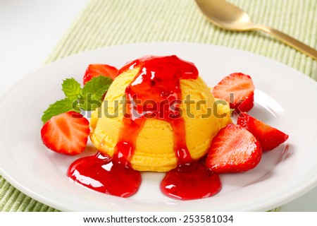 Scoop of yellow ice cream with strawberry sauce