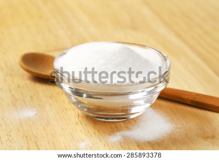 bowl of cooking soda and wooden spoon on table