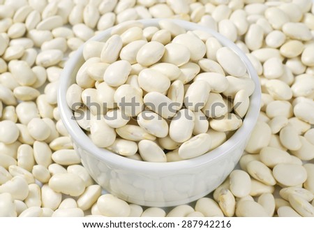 close up of raw white beans in white bowl