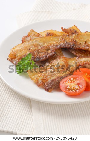 fried pork slices on white plate and place mat