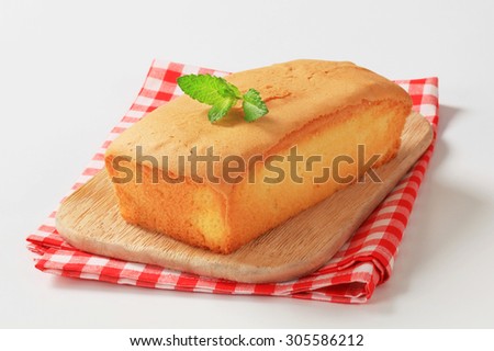 loaf of pound cake on wooden cutting board