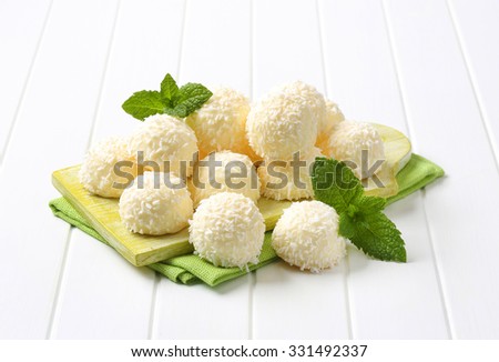 white coconut truffles on green wooden cutting board and place mat
