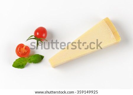 wedge of fresh parmesan cheese and cherry tomatoes on white background