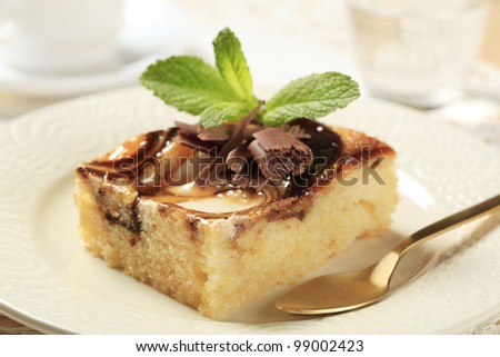 Slice of sponge cake topped with cream cheese and chocolate syrup
