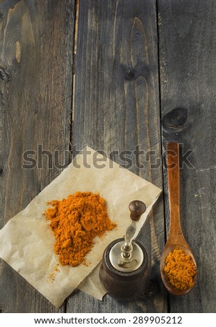 Yellow turmeric in wooden spoon on old wooden table background.Selective focus.
