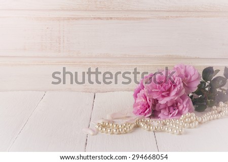 Postcard with sweet pink roses flowers on white painted wooden background  Selective focus. Place for text.Toned image.