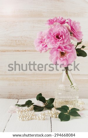 Postcard with sweet pink roses flowers on white painted wooden background  Selective focus. Place for text.