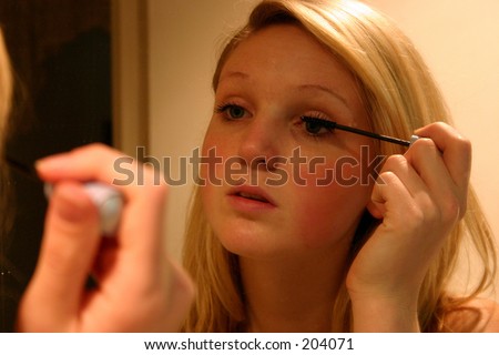 woman applying makeup in front of mirror