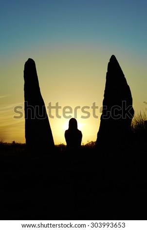 Silhouette of woman at sunset light rays. Like an angel.