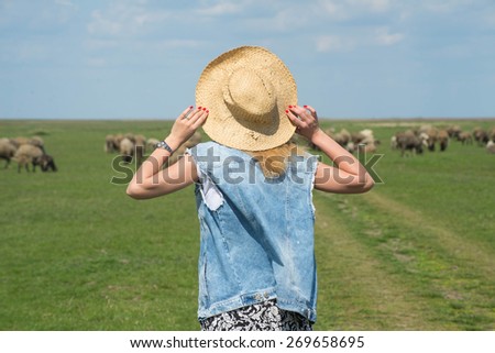 Farm life, a young girl and a flock of sheep