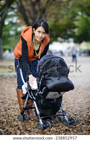Beautiful mom with baby in the baby stroller