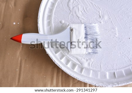 white paint with paint brush on cover paint bucket
