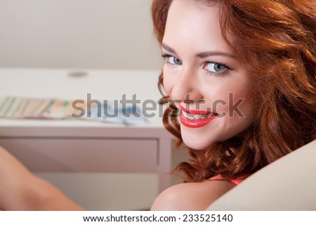 young girl in front of the table has her feet on the Desk and looking at the camera