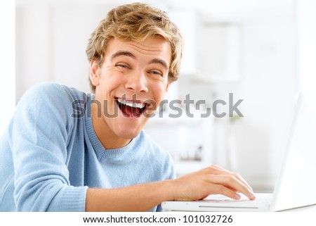 Happy young student is excited while browsing the internet with