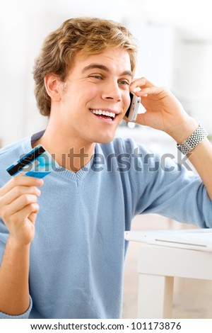 happy young student shopping on-line using credit card at home