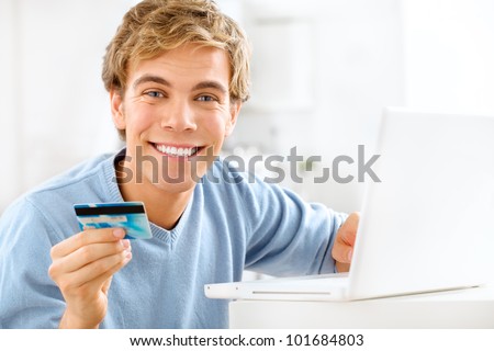 wealthy young man using credit card at home for online banking