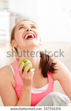 Attractive healthy happy young woman holding green apple