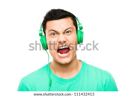 High resolution portrait crazy asian man pulling funny faces wearing headphones isolated on clean white background