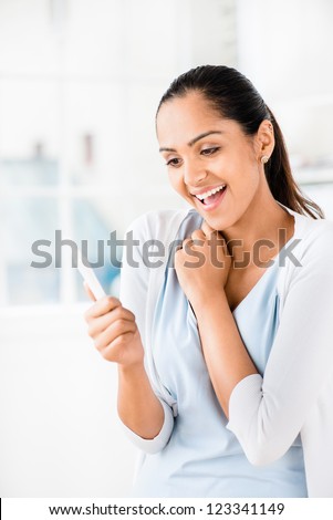 Happy Indian woman taking pregnancy test