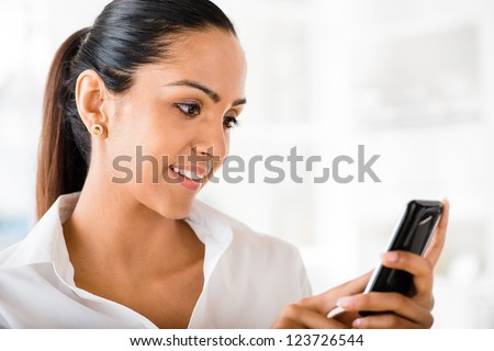 Indian business woman video messaging mobile phone happy