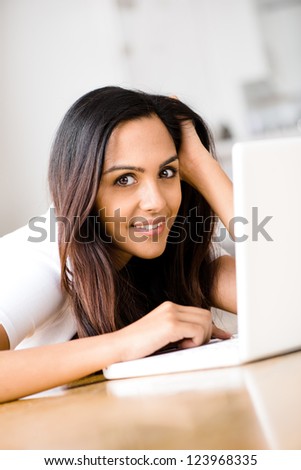 Beautiful Indian woman student using laptop computer at home