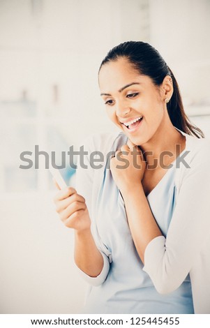 Happy Indian woman taking pregnancy test