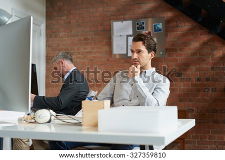 Businessman working at his computer in office thinking of business strategy
