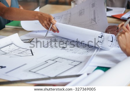Architects working on plans at business boardroom table