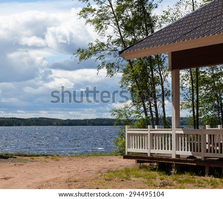 Summer landscape with lake and wooden house