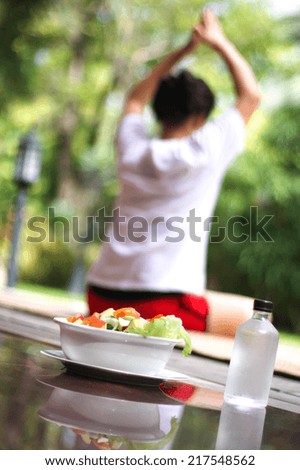 Healthy Morning Women relaxing doing yoga and salad bowl