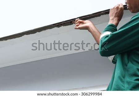 Man shape the edge of the wall with plasterer concrete cement on house construction
