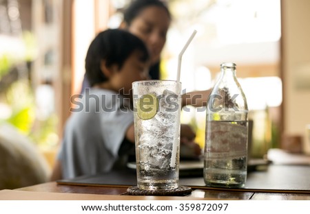 Healthy nutrition of drinking water with lemon and people in blur background