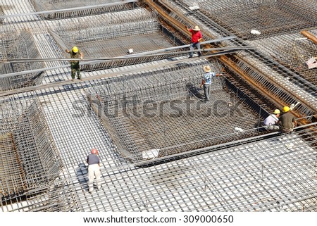 worker in the construction site making reinforcement metal framework for concrete pouring