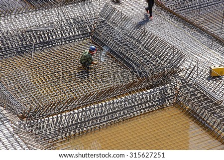 The welding worker in the construction site making reinforcement metal framework for concrete pouring